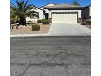 Charming single-story home features a desert landscape, palm tree, and a neutral-colored exterior at 2576 Chasma Dr, Henderson, NV 89044