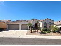 Charming single-story home featuring stucco walls, tile roof, desert landscaping, and a convenient three-car garage at 2809 Winslow Springs Dr, Henderson, NV 89052