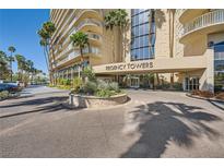 Regency Towers building entrance with manicured landscaping and easy circular access at 3111 Bel Air Dr # 18B, Las Vegas, NV 89109