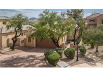 Beautiful single-story home featuring a well-maintained front yard with mature landscaping and a two-car garage at 32 Cerchio Basso, Henderson, NV 89011