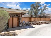 Charming single-story home featuring a wooden fence atop a stone wall and lush landscaping at 3845 S Torrey Pines Dr, Las Vegas, NV 89103