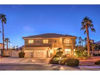 Elegant two-story home with a three-car garage, well-manicured landscaping, and a charming front porch with stone accents at 4471 Borrego Springs Way, Las Vegas, NV 89129