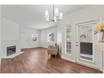 Bright living room with modern light fixture, fireplace, wood flooring, and access to the outside at 5250 S Rainbow Blvd # 1029, Las Vegas, NV 89118