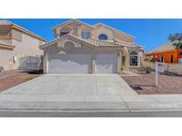 Two-story home featuring a two-car garage, desert landscaping and red tile roof at 534 Rancho Del Mar Way, North Las Vegas, NV 89031