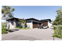 Contemporary home showcasing a multi-car garage, desert landscaping, and modern architectural details at 5855 St Ebbes Ct, Las Vegas, NV 89131