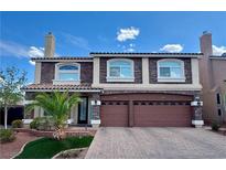 Charming two-story home with a brick driveway, a two-car garage, a landscaped yard, and a beautiful stone facade at 6205 Windy Oaks Ct, Las Vegas, NV 89139