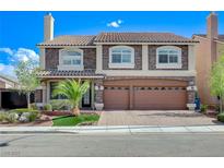 Charming two-story home featuring a tile roof, brick accents, and a well-manicured lawn at 6205 Windy Oaks Ct, Las Vegas, NV 89139