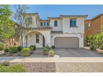 Charming two-story home with stucco siding, arched entryway, and manicured landscaping at 632 Cadence Vista Dr, Henderson, NV 89011