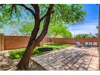 Well-kept backyard with a charming patio, green space and mature tree at 10220 Adobe Mountain St, Las Vegas, NV 89178