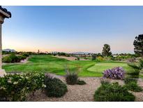 Scenic view of the golf course with lush green grass, desert landscaping, and beautiful mountain views in the background at 10562 Cerotto Ln, Las Vegas, NV 89135