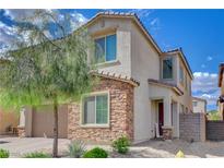 Charming two-story stucco home with a stone facade, a well-manicured lawn, and a tree-lined street at 1114 Junipine Ave, North Las Vegas, NV 89081