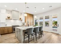 Modern kitchen with a marble island, stainless steel appliances, and an open view to the backyard pool at 1343 Panini Dr, Henderson, NV 89052