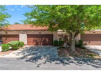 Charming townhome featuring a private garage, quaint landscaping and a terra cotta tiled roof at 2486 Sabado St, Las Vegas, NV 89121