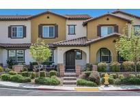 Charming two-story townhome featuring stucco siding, a tiled roof, and a cozy front patio with seating area at 3179 Mura Del Prato Ave, Henderson, NV 89044
