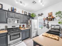Well-lit kitchen with gray cabinets, stainless steel appliances and plenty of storage at 6324 Desert Leaf St # 3, North Las Vegas, NV 89081