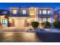 Charming two-story home featuring manicured landscaping and a two-car garage at twilight at 6750 Quapaw St, Las Vegas, NV 89149