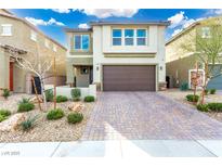 Charming two-story home featuring a brick-paved driveway and a well-maintained, drought-resistant landscaped yard at 7733 Rosebark Cliffs St, North Las Vegas, NV 89084
