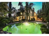 A luxurious backyard oasis featuring a sparkling pool, spa, and lush landscaping at 9000 Opus Dr, Las Vegas, NV 89117