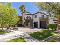 Two story home featuring a brick driveway, manicured lawn, and desert landscaping at 9501 Balatta Canyon Ct, Las Vegas, NV 89144