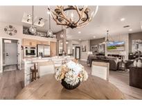 Bright, open-concept kitchen and living room featuring modern appliances and decorative lighting at 10713 Shoalhaven Dr, Las Vegas, NV 89134