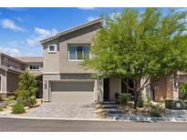 Contemporary two-story home featuring a neutral color scheme, paver driveway and low maintenance landscaping at 10954 Free Flow Pl, Las Vegas, NV 89138