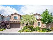 Charming two-story home featuring a brick facade, well-maintained landscaping, and a spacious three-car garage at 12018 Vento Forte Ave, Las Vegas, NV 89138