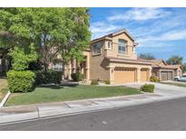 Charming two-story home with a three-car garage, lush landscaping, and well-maintained lawn at 1717 Double Arch Ct, Las Vegas, NV 89128