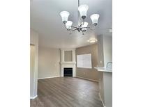 Bright living room featuring a fireplace, modern lighting, and wood-look flooring at 1881 W Alexander Rd # 1128, North Las Vegas, NV 89032