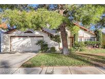 Charming single-Gathering home featuring a well-maintained lawn, mature trees, and an attached two-car garage at 4680 Freshwater Dr, Las Vegas, NV 89103