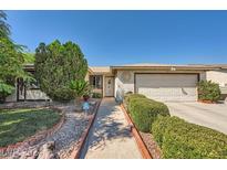 Charming single-story home featuring a manicured front yard with lush landscaping and a welcoming walkway at 5181 Morris St, Las Vegas, NV 89122