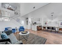 Open-concept living room featuring a staircase, modern decor, and a dining area adjacent to the kitchen at 5221 Tropical Peach Dr, Las Vegas, NV 89118