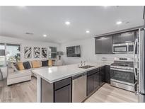 Modern kitchen features stainless steel appliances, ample counter space, and open floor plan at 6150 Foxes Dale St, Las Vegas, NV 89166