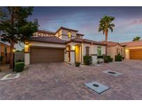 Beautiful two-story home featuring a Spanish tile roof, lush landscaping, and a spacious two-car garage at 63 Via Di Mello, Henderson, NV 89011