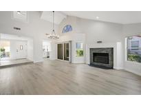 Spacious living room with vaulted ceilings, fireplace, and new floors at 7012 Bright Springs Ct, Las Vegas, NV 89113