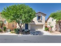 Inviting two-story home featuring a two-car garage, lovely desert landscaping, and charming architectural details at 8824 Charm Canyon Ave, Las Vegas, NV 89178
