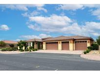 Beautiful single-story home featuring a tile roof, three-car garage, and desert landscaping at 8985 S Tomsik St, Las Vegas, NV 89113