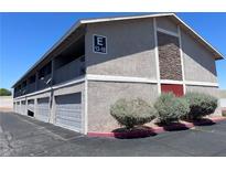 Two-story apartment building featuring private garages and upper-level balconies under a clear blue sky at 100 S Crestline Dr # 18, Las Vegas, NV 89107