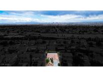 Expansive aerial view of a suburban neighborhood showcasing single-Gathering homes with the city skyline in the distance at 1027 Dawn Valley Dr, North Las Vegas, NV 89031