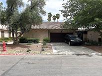 Charming single-story home featuring a tile roof, desert landscaping, and a two-car garage at 2480 Domingo St, Las Vegas, NV 89121