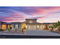 Beautiful two-story home with a three car garage and desert landscaping against a colorful sunset at 4330 Oasis Hill Ave, North Las Vegas, NV 89085