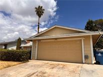 Attached two-car garage with palm tree in the yard adds to the home's curb appeal at 6460 Linda Ln, Las Vegas, NV 89103