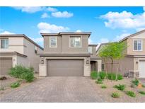 Charming two-story home featuring a brick driveway, neutral color palette and well-manicured landscaping at 7128 Port Stephens St, North Las Vegas, NV 89084