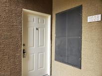 Beige front door with six panels, a peephole, and a modern key pad lock; unit number 1028 is visible at 8070 W Russell Rd # 1028, Las Vegas, NV 89113