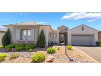 Charming single-story home featuring a stone facade, manicured landscaping, and a two-car garage at 10579 Garden Rose Dr, Las Vegas, NV 89135