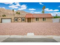 Charming single-story home with a red tile roof, desert landscaping, and mountain views at 138 Palma Del Rio, Las Vegas, NV 89110