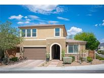 Two-story tan home featuring a brown two-car garage, front yard landscaping, and an arched front entryway at 2198 Maderno St, Henderson, NV 89044