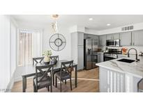 Bright dining area with modern table set and view to the updated kitchen and stainless steel appliances at 3425 E Russell Rd # 202, Las Vegas, NV 89120