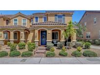 Charming two-story home with a blue front door, landscaped yard, and inviting curb appeal at 3514 Punta Tersiva Ln, Henderson, NV 89044