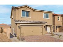 Inviting two-story home showcasing a neutral color palette, paired with a spacious two-car garage and brick driveway at 4219 Gold Desert St, North Las Vegas, NV 89032