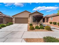 Inviting single-story home featuring desert landscaping and a spacious two car driveway leading to an attached garage at 4436 Hatch Bend Ave, North Las Vegas, NV 89031